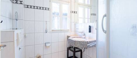 Une salle de bain moderne équipée de toilettes, d’un lavabo et d’une douche.