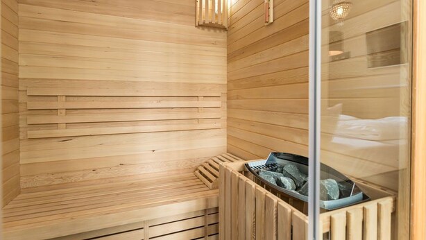 En sauna med trævægge og en bænk.