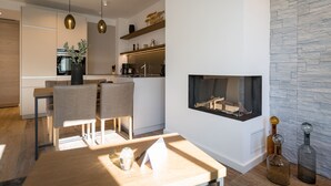 A modern kitchen with a built-in stove, wooden cabinets, and pendant lighting.