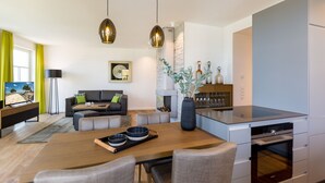 A modern kitchen with a dining area, a sofa set, and a fireplace. - Beachhouse Bansin, App. 10 (Heringsdorf)