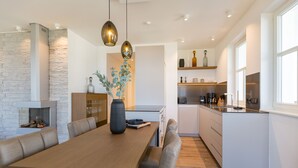 A modern kitchen with a central island, built-in appliances, and pendant lighting. - Beachhouse Bansin, App. 01 (Heringsdorf)