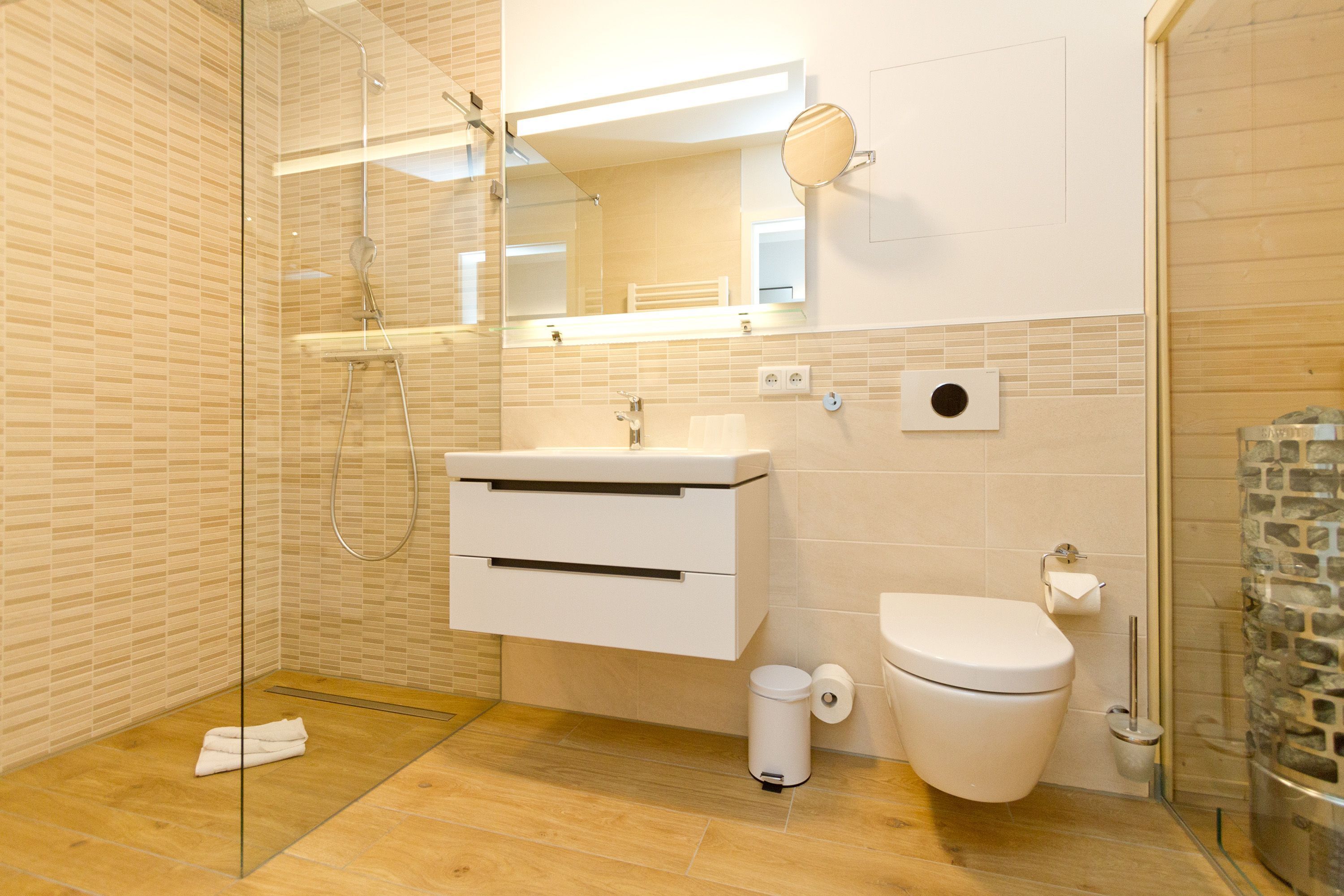 Une salle de bain moderne avec une douche à parois de verre, un lavabo blanc et des toilettes.