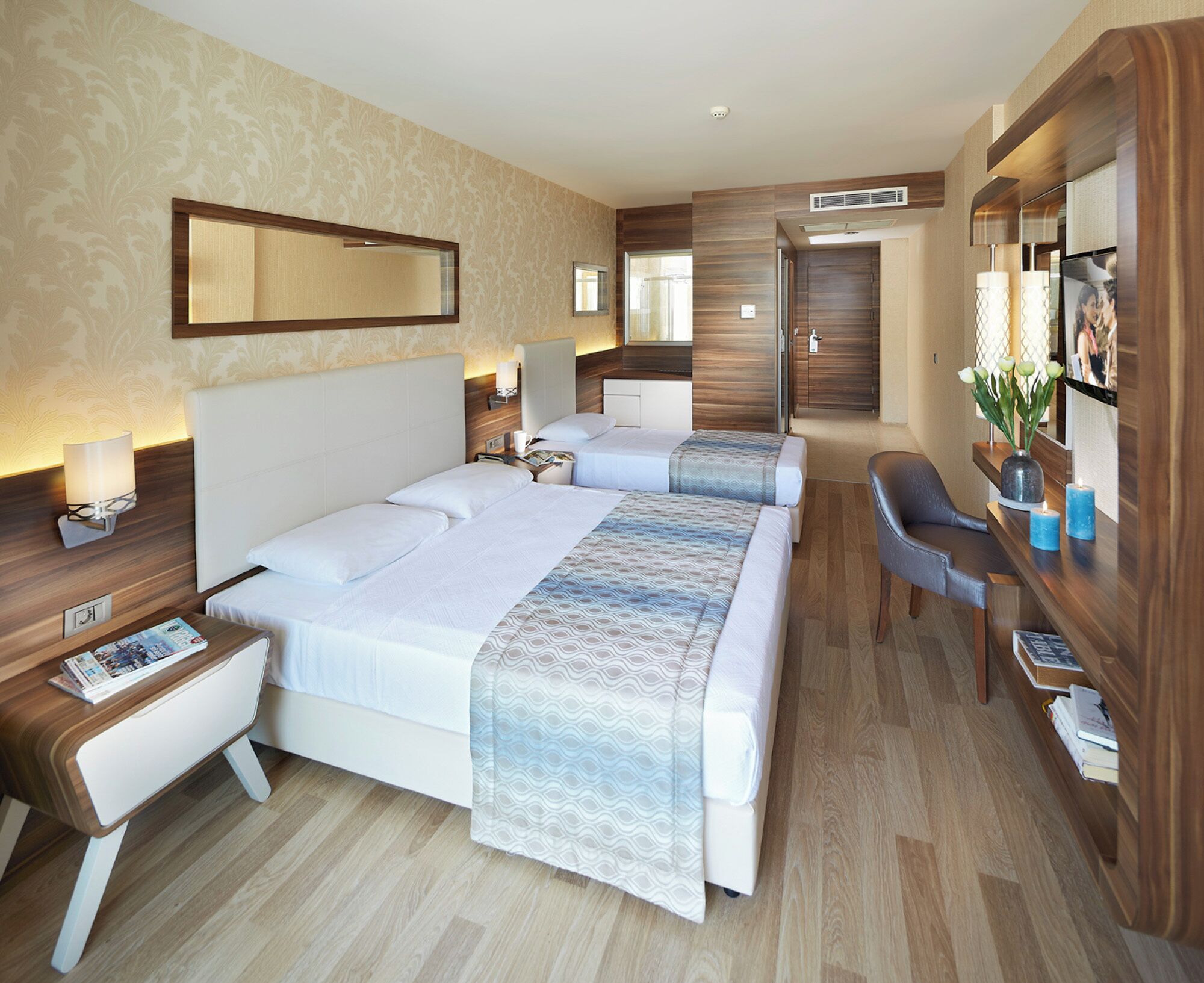 A hotel room with a large bed, bedside tables, a desk, and a chair.