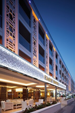 A hotel with a modern facade, a glass entrance, and outdoor seating. - Emre Hotel And Emre Beach Hotel (Marmaris)