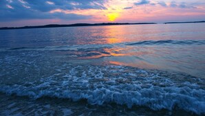 A beach with waves at sunset.