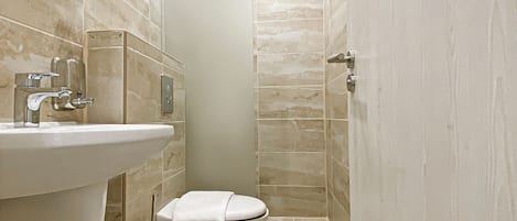 A modern bathroom with a sink, toilet, and shower.