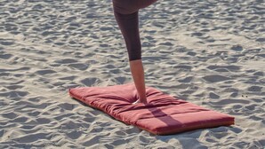 A person practicing yoga on a mat at the beach. - Villa Natalia (Corfu)