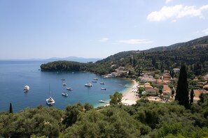 A coastal town with a beach, boats, and buildings. - Villa Natalia (Corfu)