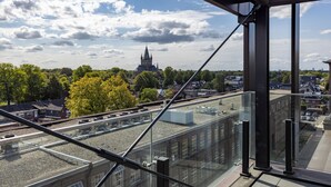 Un edificio alto con vista a un castillo histórico y un río.