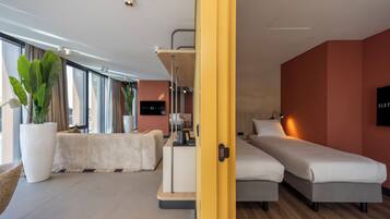 A modern hotel room with a bed, bedside table, and a large window.