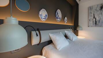 Ein modernes Hotelzimmer mit einem großen Bett, zwei Nachttischlampen und dekorativen Wandplatten.