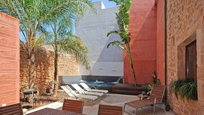 A courtyard with a hot tub, lounge chairs, and a table with a basket of fruits. - Muralles - Central house with pool, air conditioning, and wifi in Alcúdia (Alcúdia)