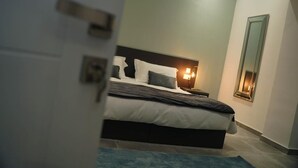Um quarto com cama, luminárias de cabeceira e mesa de apoio.