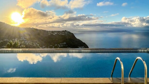 A pool with a view of the sea and a sunset. - Villa Acacia- Spectacular Ocean view & heated pool (Arco Da Calheta)