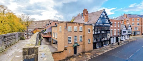 A traditional half-timbered building with a stone bridge in the foreground.