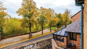 A residential area with a brick house, a covered patio, and a pathway leading to a bicycle. - Deva Leisure (Chester)