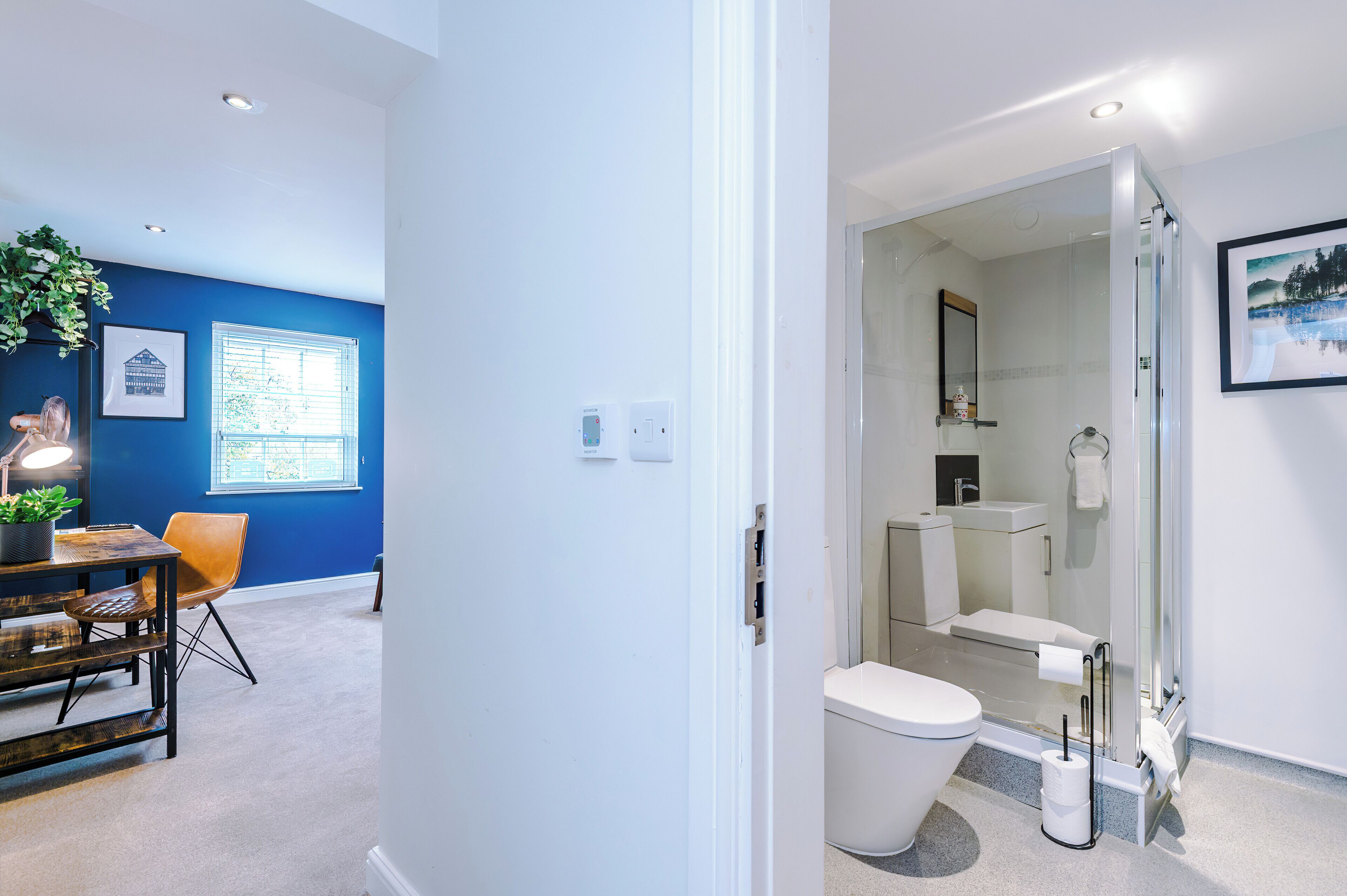 A modern bathroom with a glass shower enclosure, a toilet, and a sink.