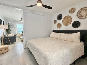 Ein Schlafzimmer mit einem Bett, einem Deckenventilator und Wanddekoration.
