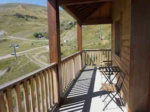 A wooden balcony with a view of a mountainous landscape and a ski lift. - Apartment with pets, parking - 6 guests (Orcières Merlette)