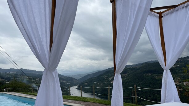 A bedroom with a view of a lake and mountains.