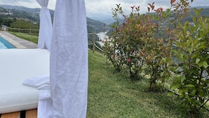 A bedroom with a view of a pool and hills.