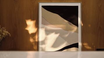 Una obra de arte enmarcadas con motivos abstractos sobre una pared de madera.