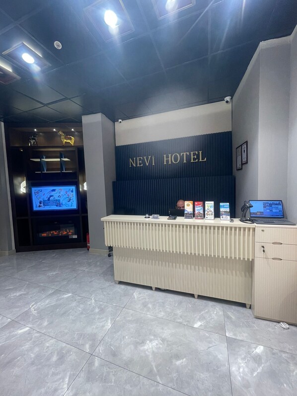 Una mesa de recepción de hotel con un letrero que dice "NEVI HOTEL".
