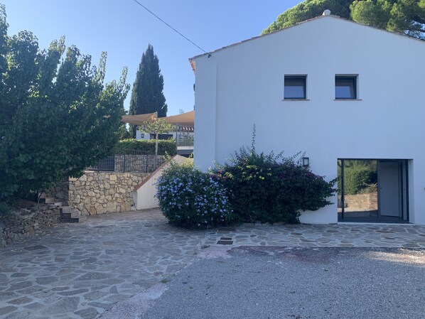 A modern building with a stone staircase and a gravel driveway.