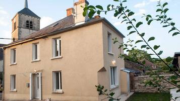 Un bâtiment à deux étages, doté d’une façade beige, de nombreuses fenêtres et d’une petite structure en forme de tour sur le toit.