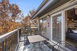 Enjoy a tranquil outdoor space with a table and chairs, surrounded by lush trees and a sliding door leading to a cozy interior.