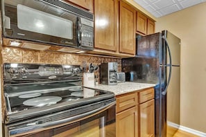 Enjoy cooking in this fully equipped kitchen with a range hood, microwave, and refrigerator.