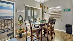 Ein Essbereich mit Tisch und Stühlen, ein Blick durch eine Tür sowie dekorative Elemente an den Wänden.