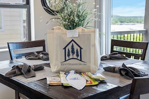 Ein Esstisch mit einer Tasche mit dem Aufdruck 'RENTBRANSON.COM' und einem Blumenstrauß.