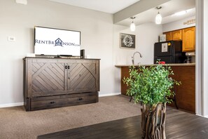 A modern kitchen with wooden cabinets, a built-in refrigerator, and a countertop. - Lake View Condo, Spacious & Only 1 Mile to Silver Dollar City – 1204 (Branson)