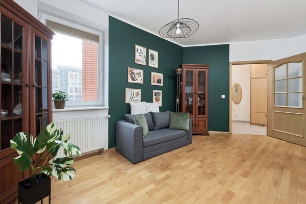 A cozy living room with green walls, stylish decor, and a comfortable seating area.