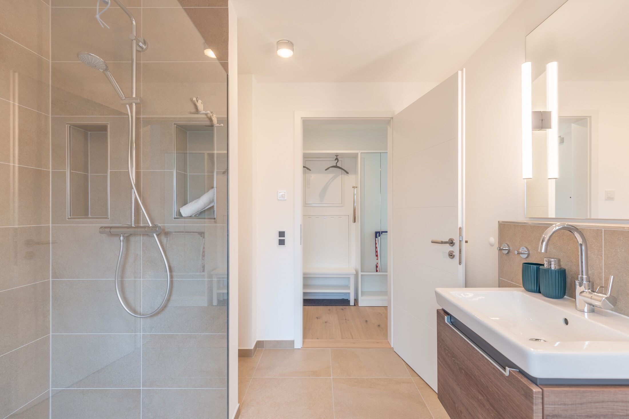 Une salle de bain moderne avec une douche, un lavabo et un miroir.