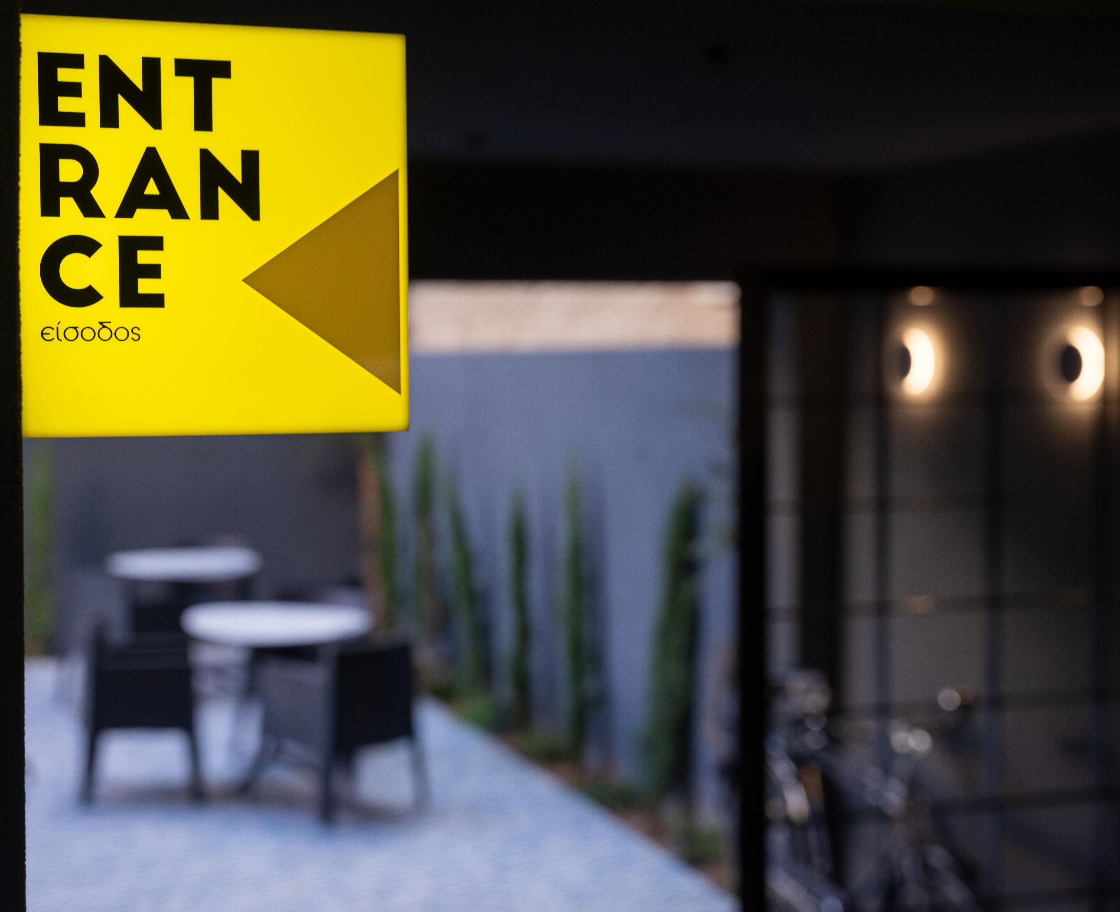 A yellow sign with the word "ENTRANCE" and an arrow pointing left, indicating the direction to the entrance.