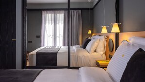 A modern hotel room with a large bed, a bedside table, and a mirror. - 3 Pines Design Living (Heraklion)