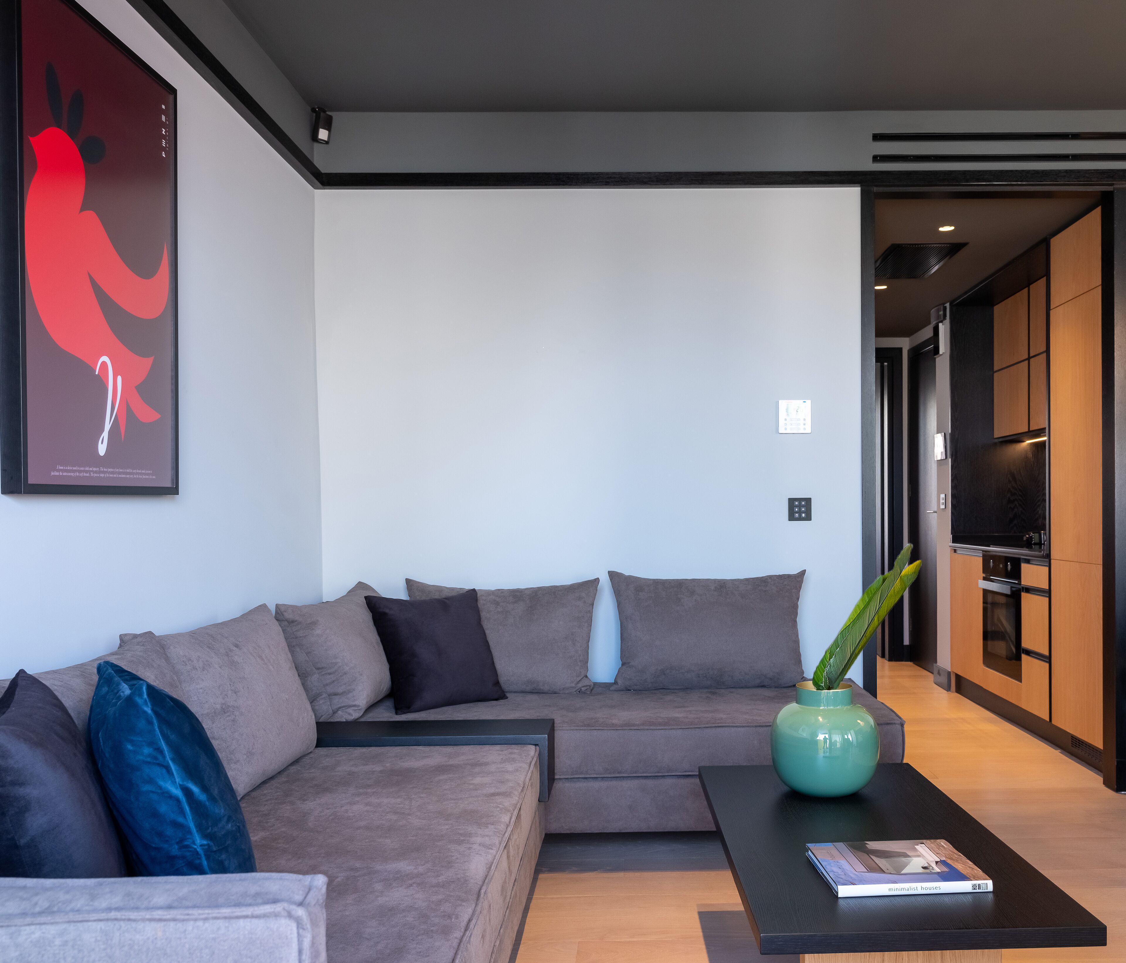 A modern living room with a sectional sofa, a coffee table, and a decorative vase.