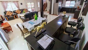 Ein großzügiger Wohnbereich mit Esstisch, Sofa und einer Küche im Hintergrund.
