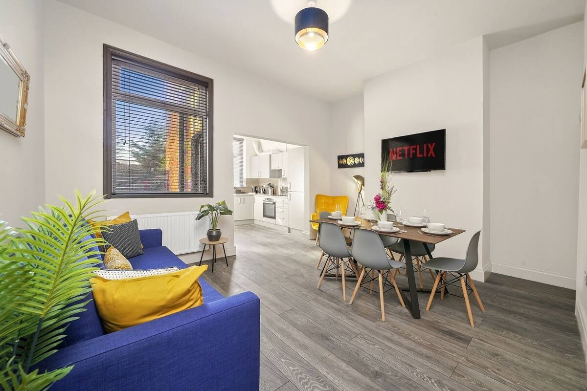 A modern apartment with a living room, dining area, and kitchen.