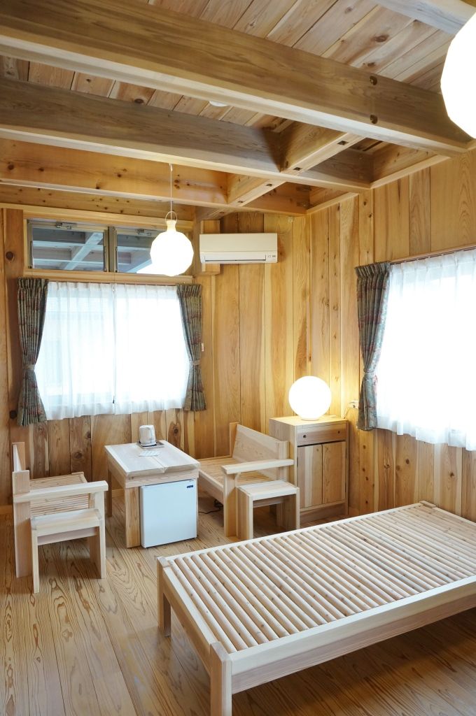 Un interior de madera con una cama, una mesa y sillas.