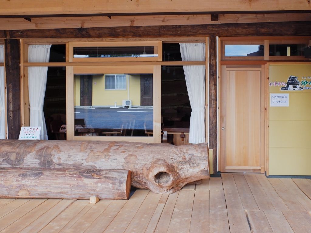 Una estructura de madera con ventanas amplias y una cepa al frente.