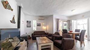A living room with a sofa set, a coffee table, a TV, and a dining area with chairs and a table. - C22 Quinta do paraiso Superbly Appointed and Furnished Bungalow (Carvoeiro)