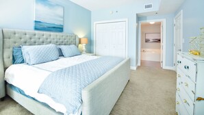 A bedroom with a large bed, a dresser, and a bathroom visible through an open door. - *Ariel Dunes II 108 Beach access*Pools* (miramar beach)