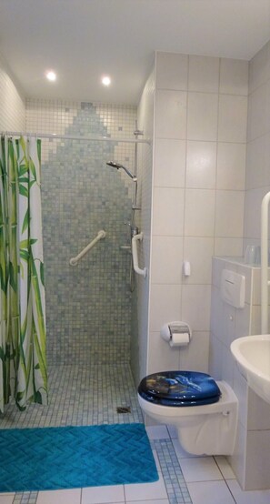 Ein Badezimmer mit Dusche, Toilette und Waschbecken.