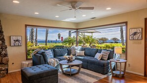 A modern living room with a sectional sofa, a round coffee table, and a view of a golf course. - Bluewater Retreat - Ocean Views from the heart of Santa Barbara (Santa Barbara)