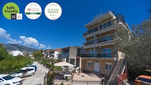 Un immeuble à plusieurs étages doté de balcons, d’une cour pavée et offrant une vue sur les environs.