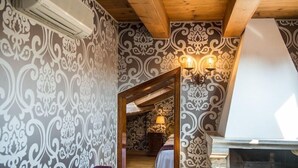 A room with patterned wallpaper, a wooden ceiling, a fireplace, and a staircase leading to another room. - Hotel Casa Nicolo Priuli (Venice)