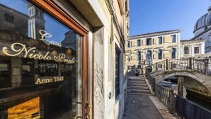 A narrow street with a historic building featuring a large window with the inscription "Casa Nico Polo Anno 1848". - Hotel Casa Nicolo Priuli (Venice)